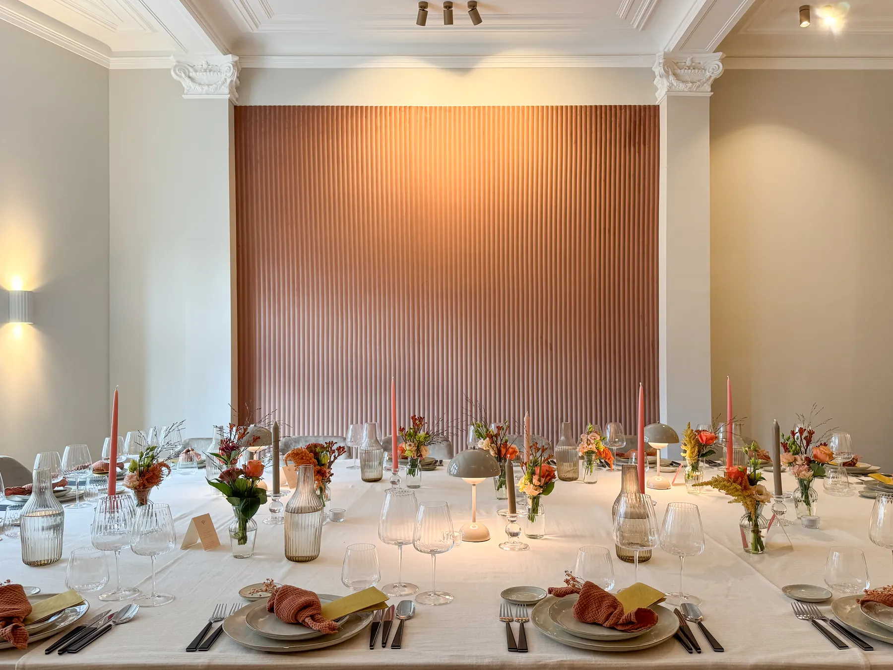 Een kaarsverlichte tafel met kristalglazen en bleke rozen